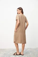 Vestido color beige de lino, corte recto, con cuello en V y mangas cortas. Tiene bolsillos laterales.