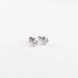 Caravanas tipo abridores de oro blanco 18k con engaste de circonia central brillante.