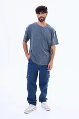 Pantalón cargo de denim negro con corte holgado, bolsillos laterales con solapa y cierre frontal con botón.