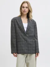 Blazer de sarga con diseño oversize, cuello con solapas y cierre frontal de dos botones. Presenta un estampado de cuadros en tonos gris oscuro y una estructura definida.