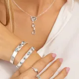 Brazalete abierto de plata 925 con tres piedras topacio azul ovaladas, ajustable a la muñeca.