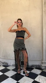 Falda asimétrica de tejido lurex negro y dorado, con pretina elástica y apliques de crochet en el ruedo.