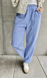 Pantalón de pijama con rayas verticales azules y blancas, corte recto y cintura elástica.
