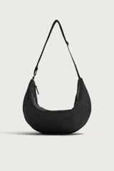 Bolso de hombro tipo hobo de nylon negro, con diseño curvo y asa ajustable. Cuenta con compartimento principal con cierre de cremallera y bolsillo interior con cremallera.