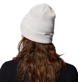 Gorro tipo beanie de tejido acanalado en color arena, con vuelta en el borde y parche rectangular con el logo de la marca en la parte frontal.