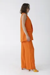 Pantalón negro de vestir de corte palazzo con cintura alta y bolsillos laterales.