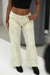 Pantalón de jean tiro medio, color crema o blanco roto, con estampado sutil en tono grisáceo. Corte recto o ligeramente acampanado.