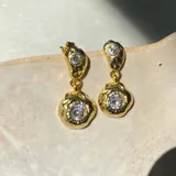 Par de aros colgantes dorados con circonias engarzadas.