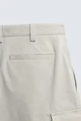 Bermuda cargo de algodón color beige claro, con corte relajado, bolsillos laterales de parche con solapa y bolsillos traseros de vivo.
