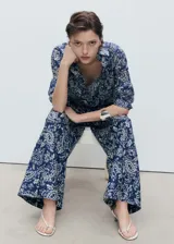 Pantalon de corte recto y tiro medio, confeccionado en tejido de algodón con estampado paisley. Presenta cintura con elástico y bolsillos laterales.