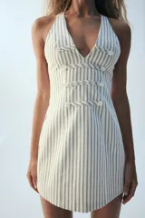 Vestido mini Zara de rayas diplomáticas, con escote en pico, diseño sin mangas, doble botonadura frontal decorativa y cierre lateral con cremallera oculta.