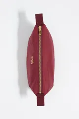 Neceser de diseño trapecio confeccionado en nylon color bordó, con cierre superior y logo de la marca estampado en dorado en el frente.