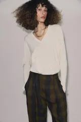 Pantalón de tiro alto con diseño fluido y estampado de cuadros en tonos oscuros. Presenta pliegues frontales, bolsillos delanteros con solapa y cierre frontal con cremallera, botón y ganchos metálicos.