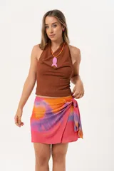 Minifalda multicolor con estampado abstracto en tonos naranja, rosa y violeta. Diseño cruzado con lazo lateral.