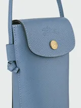 Funda para teléfono tipo crossbody de cuero granulado en color azul, con solapa frontal, cierre de botón a presión dorado y correa larga ajustable.