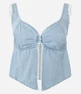 Top cropped de jeans celeste con escote corazón, breteles anchos y abertura frontal central abotonada. Los bordes del escote y la abertura están decorados con un ribete de encaje blanco tipo picot.