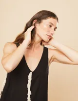 Vestido largo blanco de lino con escote en V y flecos de algodón en los bordes.