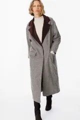 Tapado de corte recto con estampado de pata de gallo en tonos gris y marrón. Presenta solapas anchas en contraste de pana color chocolate, cierre frontal con botones y bolsillos laterales amplios.