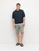 Bermuda chino de corte recto, con bolsillos laterales estilo italiano y bolsillos traseros con ojal y botón.