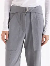 Pantalón de punto liso color gris, de corte recto y silueta relajada. Presenta cintura alta con cinto integrado, bolsillos aplicados en el delantero y tajos frontales en el ruedo.