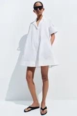 Vestido corto camisero de la ZW Collection de Zara, confeccionado en hilatura de algodón de color verde. Presenta cuello solapa, manga corta, diseño en línea evasé y cierre frontal con botones.