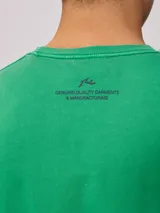 Remera color crema de hombre, marca Rusty, con estampado frontal en color rojo con el logo de la marca y la leyenda "Rusty Worldwide Supply Co. Since 1985".