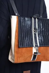 Mochila de cuero vacuno color negro, con tapa de cuero con textura croco color bordó y detalles en blanco. Tiene mosquetón de seguridad exterior, cierre interior, dos bolsillos interiores (uno con cierre y otro para celular), sujetador de llaves, forro completo y tiras ajustables. Se puede usar como mochila o como cartera.