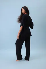 Conjunto de dos piezas (camisa y pantalón) de tejido acanalado gris, con camisa estilo kimono de manga ancha y cuello V cruzado, ajustada a la cintura con un lazo de tela.