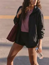 Campera deportiva negra de corte ajustado, con cierre frontal, cuello alto y mangas largas con puños elásticos.
