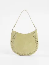 Cartera de hombro color verde claro, con diseño de media luna y detalle trenzado con ojales metálicos plateados en el borde. Incluye una correa corta para el hombro y una correa larga extraíble para llevar cruzada.