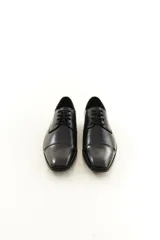 Zapato de vestir acordonado de cuero vacuno marrón, con puntera distinguida y suela con sutil tacón.