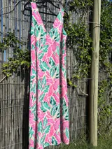 Vestido largo sin mangas, con escote en V, de corte holgado y estampado botánico en tonos fucsia/rosado y verde sobre fondo claro.