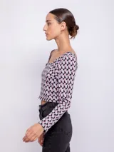 Top de tejido de punto con estampado geométrico en blanco y negro, de manga larga y cuello redondo.