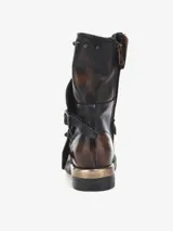 Botas de caña media color gris con efecto desgastado, cierre lateral con cremallera, apliques de tachas metálicas y correa con hebilla.