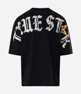 Remera oversized de algodón negro, con cuello redondo y mangas cortas. Presenta un gran estampado en la espalda con la inscripción "True Star" en tipografía gótica y detalles de estrellas.