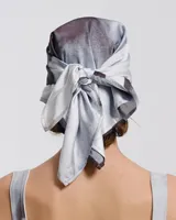 Pañuelo para la cabeza con estampado abstracto en tonos grises y negros.