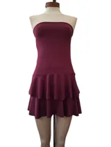 Vestido corto color uva, con diseño strapless, cuerpo ajustado con frunces y falda con volados en capas.