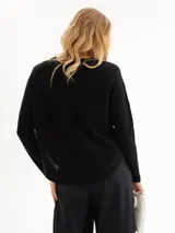 Sweater negro de punto acanalado con cuello redondo y manga larga.