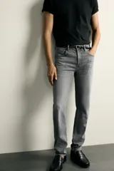 Jeans slim fit de color negro para hombre, con tiro medio, diseño de cinco bolsillos y cierre frontal con cremallera y botón.