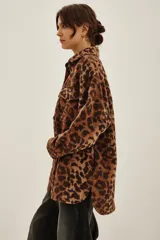 Tapado tipo sobrecamisa con estampado animal print, de corte recto y largo a la cadera. Presenta cuello camisero, cierre frontal con botones y dos bolsillos frontales con solapa.