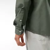 Camisa de corte regular fit en tejido oxford color verde, con cuello abotonado y cierre frontal de botones.
