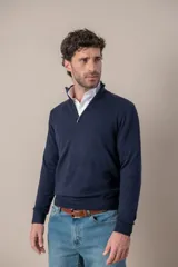 Sweater de lana merino con cuello alto y cierre frontal parcial, de manga larga con puños y ruedo acanalados.