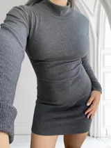 Vestido corto gris topo de lanilla, con cuello alto y mangas largas.