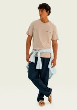 Remera de corte regular y manga corta en color naranja, con pequeño estampado tipográfico y gráfico de ancla en el pecho.