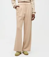 Pantalón wide leg de modal color beige, con tiro alto, pliegues delanteros y bolsillos laterales tipo cuchillo. Cuenta con trabillas en la cintura.