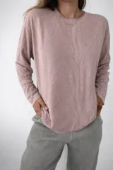 Buzo de tejido de punto con diseño de estampado tipo cebra y sutiles hilos dorados integrados. Presenta cuello redondo, mangas largas y un corte holgado.