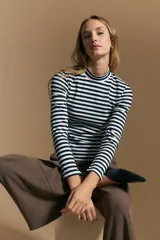 Polera de cuello alto y manga larga, confeccionada en tejido elástico con diseño de rayas horizontales en azul marino y blanco.