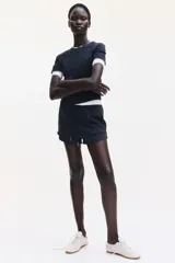 Remera negra entallada de punto de algodón elástico, con cuello redondo fino ribeteado y bajo recto.