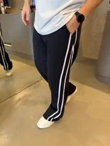 Pantalón deportivo de corte baggy y estilo oversize, color negro con doble franja lateral blanca. Confeccionado en algodón premium, cuenta con bolsillos laterales y cintura elástica.