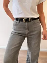 Jeans palazzo de corte ancho, color gris, tiro medio y botamanga con dobladillo ancho fijo. Incluye cinto negro con hebilla metálica.
